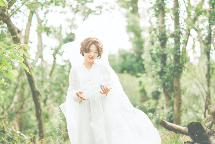 明るい森林で真っ白な服を着た女性の画像